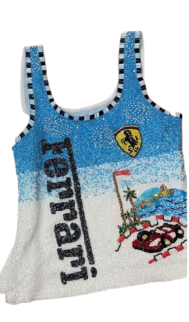 A sparkly, beaded tank top featuring Ferrari branding, with a blue-to-white gradient design, the Ferrari shield logo, and a red race car graphic.